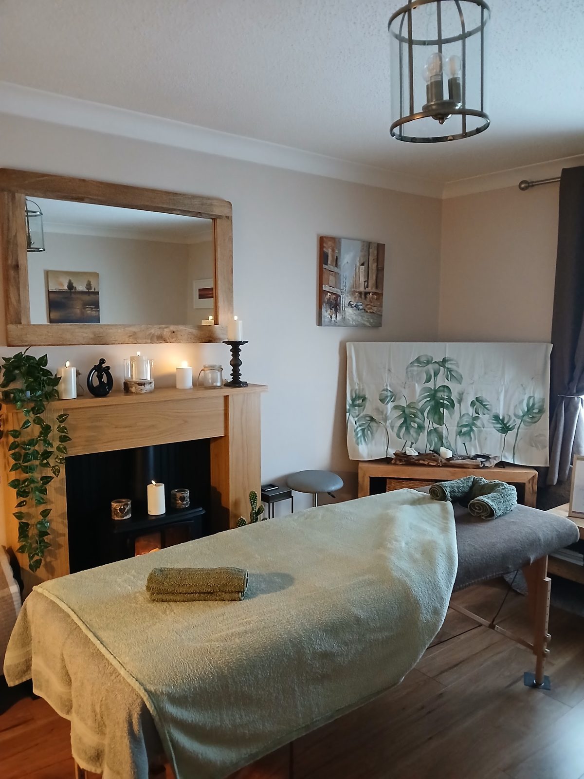 The treatment room with the massage couch, mirror and fireplace